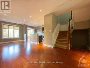 Ottawa townhouse for rent - A spacious living room with hardwood floors and a staircase leading to the upper level.