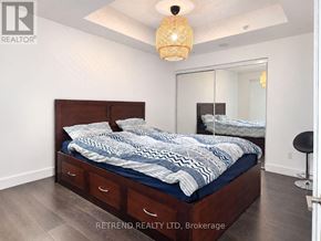 Toronto (Moss Park) condo for rent - A bedroom with a bed, nightstands, and a mirror.