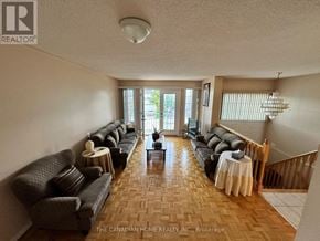 Vaughan (Maple) apartment for rent - A living room with a long couch and a dining table.
