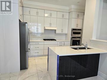Richmond Hill (Oak Ridges Lake Wilcox) apartment for rent - A kitchen with white cabinets and a black refrigerator.