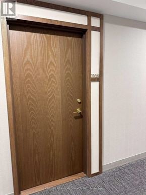 Vaughan (Vaughan Corporate Centre) condo for rent - A wooden door with a brass handle and a brass plate with the number 1036 on it.
