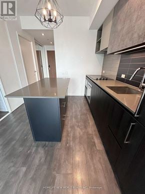 Vaughan (Vaughan Corporate Centre) condo for rent - A modern kitchen with dark wood floors and a large island.