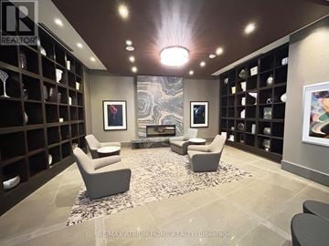 Markham (Unionville) condo for rent - A living room with a rug, two chairs and a fireplace.