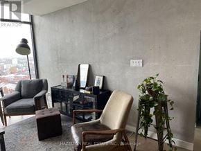 Toronto (Waterfront Communities) condo for rent - A room with a chair, a table, and a plant.