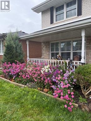 Mississauga (Applewood) apartment for rent - A house with a white porch and a flower bed in front.