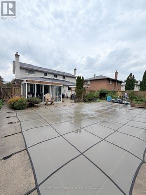 Mississauga (Applewood) apartment for rent - A wet backyard with a house and a car in the background.