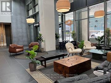Toronto (Waterfront Communities) condo for rent - A living room with a brown chair and a wooden puzzle box coffee table.