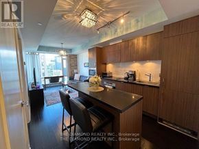 Toronto (Waterfront Communities) condo for rent - A modern kitchen with wooden cabinets and a black countertop.