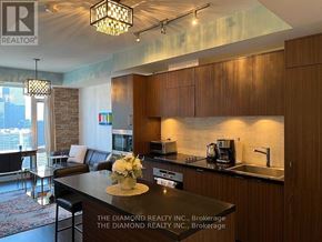 Toronto (Waterfront Communities) condo for rent - A modern kitchen with wooden cabinets and a black countertop.