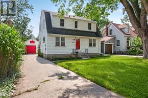 Toronto (Islington-City Centre West) apartment for rent - A white house with a red door is surrounded by greenery.