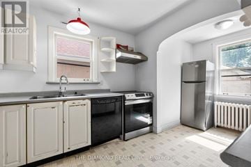 Toronto (Islington-City Centre West) apartment for rent - A kitchen with white cabinets and a black stove top oven.