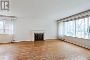 Toronto (Edenbridge-Humber Valley) apartment for rent - A large empty room with a fireplace and wooden floors.