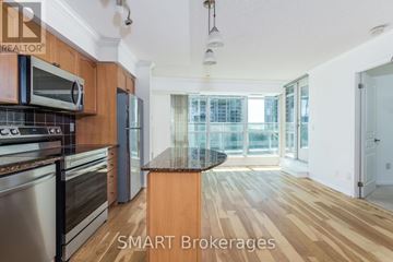 Toronto (Waterfront Communities) condo for rent - A kitchen with wooden cabinets and a black countertop.