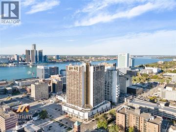Windsor condo for rent - A cityscape with a large body of water in the background and a clear sky.