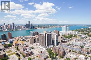 Windsor condo for rent - A cityscape with a body of water in the background and a clear sky.