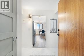 Windsor condo for rent - A hallway with a wooden door and a framed picture on the wall.
