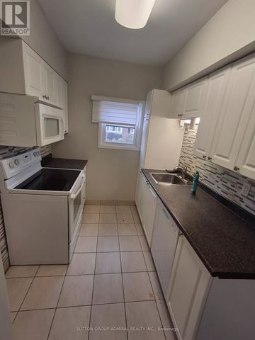 Toronto (Lawrence Park South) apartment for rent - A kitchen with white cabinets and a black counter top.