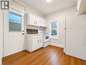 London apartment for rent - A kitchen with white cabinets and a wooden floor.