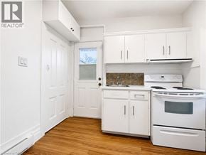 London apartment for rent - A white kitchen with wooden floors and white appliances.