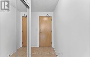 Toronto (Mount Pleasant West) condo for rent - A white hallway with a wooden door and a mirror on the wall.