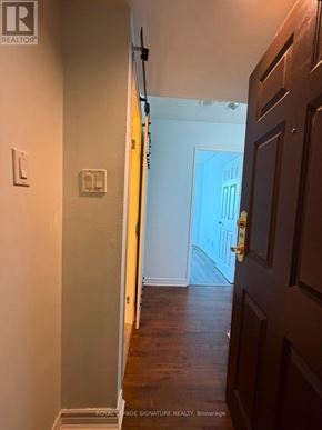 Ajax (Central West) condo for rent - A hallway with a wooden door and a white wall.