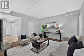 Toronto (Clairlea-Birchmount) apartment for rent - A living room with a grey couch, a glass coffee table, and a mirror on the wall.
