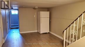 Toronto (Dovercourt-Wallace Emerson-Junction) apartment for rent - A room with a white refrigerator and a staircase with white railings.