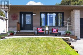 Halton Hills (Georgetown) apartment for rent - A modern house with a black door and windows, a wooden bench, and a green lawn.
