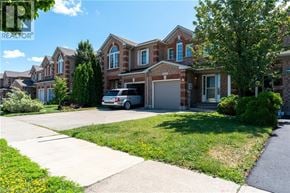 Burlington townhouse for rent - A large house with a garage and a car parked in front.