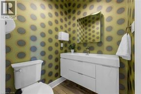 Hamilton apartment for rent - A bathroom with a toilet, sink, and mirror.