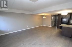 Kitchener condo for rent - A spacious room with wood flooring and a bar area.