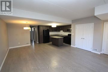 Kitchener condo for rent - A spacious living room with a kitchen in the background.