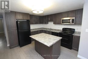 Kitchener condo for rent - A kitchen with a black fridge, black oven, and black microwave.