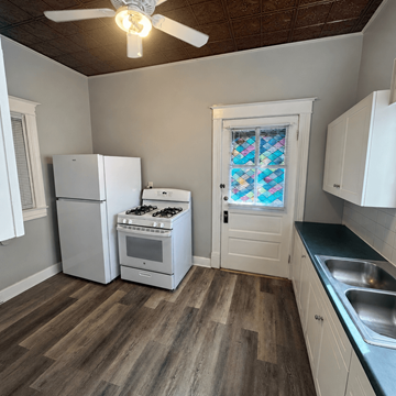 Louisville apartment for rent - A kitchen with a white fridge, stove, and cabinets.