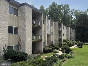 Rockville apartment for rent - A row of apartment buildings with balconies and greenery in front.