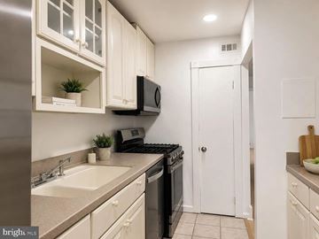Rockville apartment for rent - A kitchen with white cabinets and a black stove top oven.