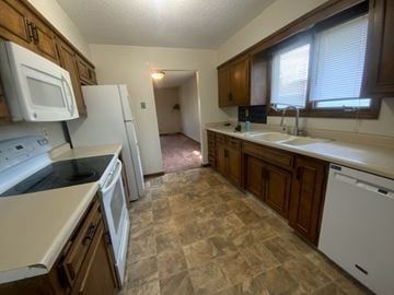 Fremont apartment for rent - A kitchen with white appliances and brown cabinets.