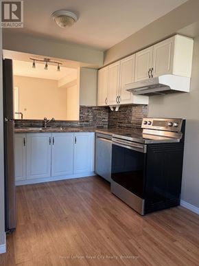 Guelph (Downtown) townhouse for rent - A kitchen with a black oven and wooden floors.