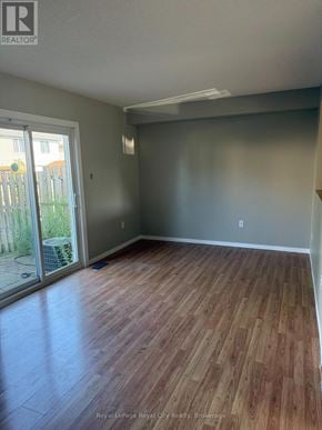 Guelph (Downtown) townhouse for rent - A room with wooden flooring and a sliding glass door.