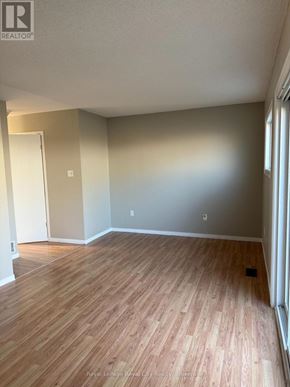 Guelph (Downtown) townhouse for rent - A room with wooden flooring and a white door.