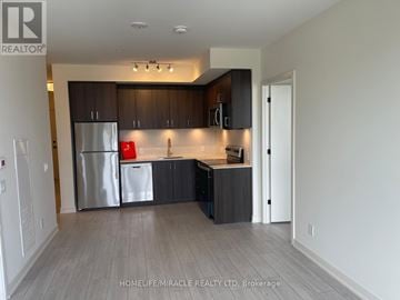 Milton (Co Coates) condo for rent - A kitchen with a refrigerator, cabinets, and a countertop.