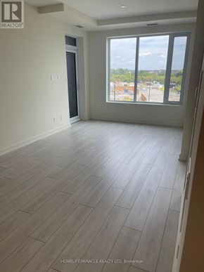 Milton (Co Coates) condo for rent - A room with a large window and wooden flooring.