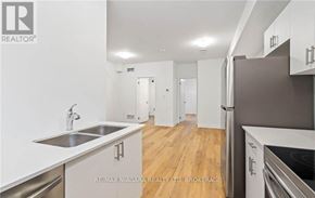 Welland (N. Welland) townhouse for rent - A modern kitchen with white cabinets and stainless steel appliances.