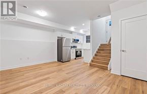 Welland (N. Welland) townhouse for rent - A spacious room with wooden flooring and a staircase leading to another room.