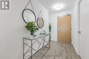 Toronto (Bayview Village) condo for rent - A hallway with a glass console table and a mirror on the wall.