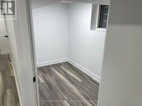 Toronto (Little Portugal) duplex for rent - A room with wooden flooring and white walls.