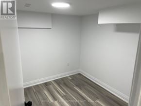 Toronto (Little Portugal) duplex for rent - A room with white walls and wooden flooring.