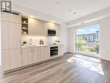 Vaughan (Vaughan Corporate Centre) condo for rent - A modern kitchen with wooden cabinets and a large window.