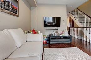 Mississauga (Lakeview) townhouse for rent - A living room with a white couch and a flat screen TV mounted on the wall.