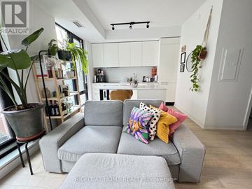 Toronto (Little Portugal) condo for rent - A grey couch with colorful pillows sits in a bright living room.